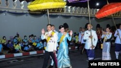 Thailand's King Maha Vajiralongkorn and Queen Suthida wave after a ceremony to celebrate the birthday of Queen Sirikit, the Queen Mother, in Bangkok, Thailand, Aug. 12, 2020. Protests have erupted in recent days denouncing the monarchy.