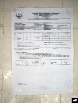 A certificate pasted to a wall at a water filtration plant, where the water is provided from a tube well, declares that the water at the site is safe, in Islamabad, Pakistan, Aug. 23, 2017.