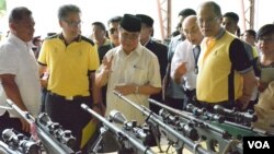 Moro Islamic Liberation Front Chairman Al Haj Murad Ebrahim (C) shows Philippine President Benigno Aquino (R) weapons turned in by Front rebels in Sultan Kudarat, Maguindanao Province, the Philippines, June 16, 2015. (VOA/Simone Orendain)