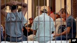 Central American men sit inside the Asociacion Casa Del Migrante "La Divina Providencia" group house Thursday, July 19, 2018 in San Luis, Sonora, Mexico. 