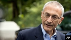 FILE - Hillary Clinton campaign chairman John Podesta speaks to members of the media outside Clinton's home in Washington. Pizzagate centers on emails that were stolen and made public by WikiLeaks in which Clinton campaign manager John Podesta and others discuss pizza. According to the theory, talk of pizza is code for pedophilia.