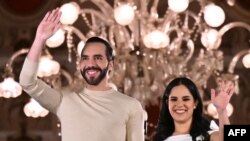 El presidente salvadoreño Nayib Bukele saluda a sus partidarios junto a su esposa, Gabriela Rodríguez, después de las elecciones presidenciales en San Salvador, el 4 de febrero de 2024. (Foto de Marvin RECINOS / AFP)