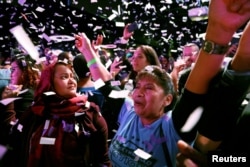 Adrian Avella and Mazeda Uddin react during the midterm election night party of Democratic congressional candidate Alexandria Ocasio-Cortez in New York City, Nov. 6, 2018.