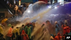 Pro-democracy demonstrators face water canons as police try to clear the protest venue in Bangkok, Thailand.