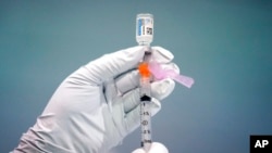 Seorang petugas pemadam kebakaran Philadelphia tengah menyiapkan suntikan vaksin COVID-19 Johnson & Johnson di salah satu lokasi vaksinasi di Philadelphia pada 26 Maret 2021. (Foto: AP/Matt Rourke)