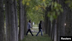 FILE - Syrian migrants walk through a temporary refugee camp in Gabcikovo, Slovakia, Oct. 8, 2015.