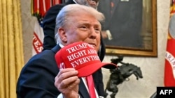 President Donald Trump holds a hat reading "Trump was right about everything" after signing an order on the supply of copper and foreign copper in the American market at the Oval Office of the White House in Washington on Feb. 25, 2025.