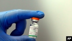 A medical worker poses with a vial of Sinopharm's COVID-19 vaccine in Belgrade, Serbia, the first European country to receive the Chinese Sinopharm coronavirus vaccine for mass inoculation, Jan. 19, 2021. 