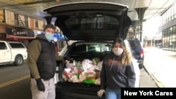 Chris Porr and his wife making food deliveries in Jackson Heights, Queens, New York. (Photo by New York Cares)
