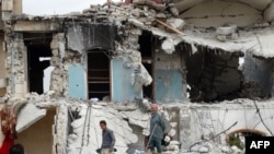 Syrians inspect the damage following a reported US-led coalition air strike against the headquarters of al-Nusra Front, 20 km west of the northern city of Aleppo on Sept. 25, 2014. 
