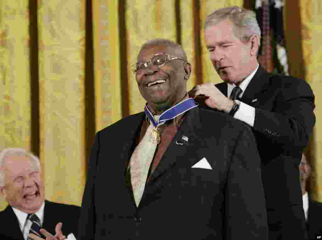 President Bush, right, bestows the Presidential Medal of Freedom to Blues Musician B.B. King, center, during a ceremony in the East Room of the White House in Washington, Dec. 15, 2006.