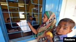 A woman checks for her name on the draft list of the National Register of Citizens in Chandamari village in the northeastern state of Assam, India, January 2, 2018.