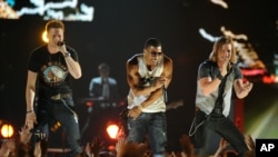 Nelly, center, and Brian Kelley, left, and Tyler Hubbard, of musical group Florida Georgia Line, perform at ACM Presents: Tim McGraw's Superstar Summer Night at the MGM Grand Garden Arena, April 8, 2013, in Las Vegas.