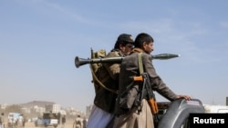 FILE - Armed Houthi followers ride on the back of a pick-up truck during a parade in solidarity with the Palestinians in the Gaza Strip and to show support to Houthi strikes on ships in the Red Sea and the Gulf of Aden, in Sanaa, Yemen, January 29, 2024. 
