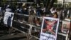 A poster featuring army chief Senior General Min Aung Hlaing is displayed on a barricade as protesters take part in a demonstration against the military coup in front of the Central Bank of Myanmar in Yangon, Feb. 11, 2021.