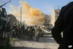 FILE - Smoke rises after an airstrike by a U.S.-led coalition warplane as Iraqi security forces advance their position during heavy fighting against Islamic State militants in Fallujah, Iraq, June 14, 2016.