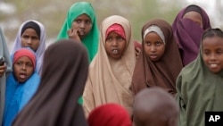 FILE - Children watch as another child is vaccinated in the town of Liboi, Kenya, July 27, 2011. Kenyan authorities on Friday launched a mass vaccination program against the human papilloma virus, or HPV.