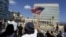 FILE - A woman waves a U.S flag in Havana, July 20, 2015.