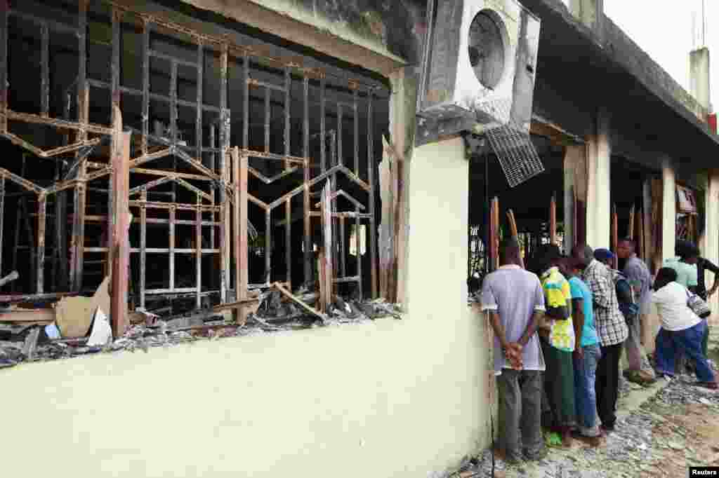 Residents peer into a building after an attack in Mpeketoni, Kenya, June 16, 2014.