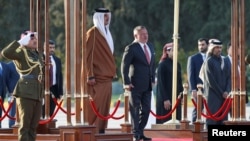 Jordan's King Abdullah II and Qatar's Emir Sheikh Tamim bin Hamad al-Thani review Bedouin honour guards at the Queen Alia International Airport in Amman, Jordan, Feb. 23, 2020. 