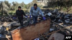 ২০২৪ সালের ১১ মার্চ গাজা ভূখণ্ডের রাফায় ইসরাইলি বোমা হামলায় ধ্বংস হয়ে যাওয়া বাড়িঘরের ধ্বংসস্তূপের মধ্যে ফিলিস্তিনিরা তাদের জিনিসপত্র খুঁজছে।