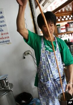 Suchart Lapaparat pours hot tea at his store inside the red shirt protest zone in central Bangkok. He says he is losing money from the protests.