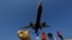 FILE - Tourists take pictures at Mai Khao Beach, as a plane approaches the Phuket International Airport in Phuket, Thailand March 17, 2016. 