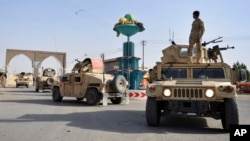 In this Aug. 12, 2018, photo, Afghan security personnel patrol in the city of Ghazni province west of Kabul, Afghanistan. 