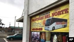 FILE - A sign advertising bus trips to California with connections to Mexico, at a shop in the predominantly Latino town of Woodburn, Ore., March 2, 2017.