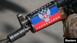A pro-Russian armed man guards a barricade in Slaviansk, Ukraine. The sticker on his rifle reads "Republic of Donetsk." April 28, 2014.