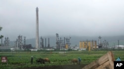 FILE - Farmers work their fields outside the Sungri Chemical Factory, an oil refinery in the Rason Special Economic Zone near North Korea's Russian and Chinese borders, July 23, 2016. 