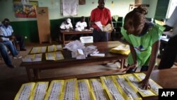 FILE - Election workers count votes after polls closed during the presidential and legislative elections in Bangui's city center, Central African Republic, Dec. 30, 2015.
