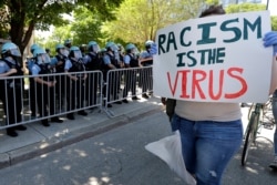 A demonstrator holds a sign during the March for Justice in honor of George Floyd, June 6, 2020, in Chicago. Demonstrators who gathered at Union Park marched through the city's West Side as the city prepared for another weekend of rallies.