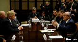 U.S. President Donald Trump listens to former New York City Mayor Rudy Giuliani during a meeting with cybersecurity experts in the Roosevelt Room of the White House in Washington, Jan. 31, 2017.
