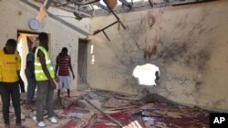 People inspect a damaged mosque following an explosion in Maiduguri, Nigeria, Oct. 23, 2015. Boko Haram is suspected to be behind bombing.