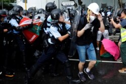 Police try to disperse protesters near a flag-raising ceremony for the anniversary of Hong Kong handover to China in Hong Kong, July 1, 2019.