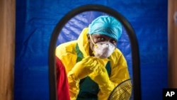 FILE -A healthcare worker dons protective gear before entering an Ebola treatment center in the west of Freetown, Sierra Leone, Oct. 16, 2014..
