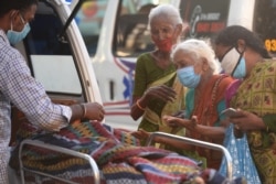 FILE - Relatives mourn next to the body of a loved one who died of COVID-19, outside a mortuary in Chennai, capital of Tamil Nadu state, India, May 5, 2021.