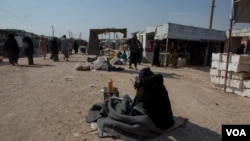 A woman shouts “Get out!” on the main street of the al-Hol Camp in Syria, Oct. 17, 2019. (Y. Boechat/VOA)