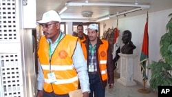 A handout picture released by the Syrian Arab News Agency (SANA) shows Arab League observers walking in a government building during their visit to Daraa in southern Syria, December 29, 2011.