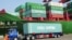 FILE - A truck transporting a container leaves the port of Qingdao, in northeast China's Liaoning province.