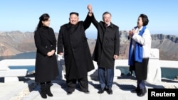South Korean President Moon Jae-in and North Korean leader Kim Jong Un pose for photographs on the top of Mt. Paektu, North Korea, Sept. 20, 2018.