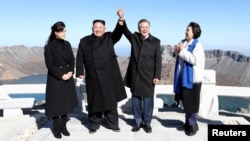 FILE - South Korean President Moon Jae-in and North Korean leader Kim Jong Un pose for photographs on the top of Mt. Paektu, North Korea, Sept. 20, 2018.