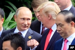 FILE - Russian President Vladimir Putin, left, and U.S. President Donald Trump talk as they arrive for the family photo session during the Asia-Pacific Economic Cooperation (APEC) Summit in Danang, Vietnam, Nov. 11, 2017.