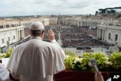 Pope Francis acknowledges pilgrims while delivering the Urbi et Orbi blessing at the end of the Easter Sunday Mass in St. Peter's Square at the Vatican, April 1, 2018.