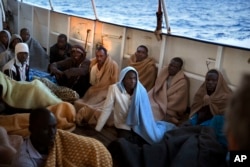 Men sit on the deck of the Golfo Azzurro rescue vessel after being rescued by members of the Spanish ONG Open Arms on the Mediterranean Sea, north of Zuwarah, Libya, June 21, 2017.