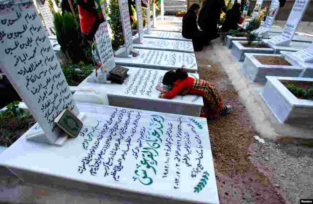 Relatives visit a grave at the Shi'ite fighters cemetery in Damascus, May 28, 2013.