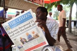 FILE - A man reads the local English-written daily newspaper "The Citizen" in Arusha, northern Tanzania, March 23, 2017.