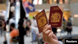 一名香港示威者在反对港版国安法的抗议中手举英国国民海外护照(BNO)。（2020年6月1日）