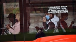 FILE - Passengers wearing face masks are seen on a bus in Bilbao, northern Spain, June 12, 2020.
